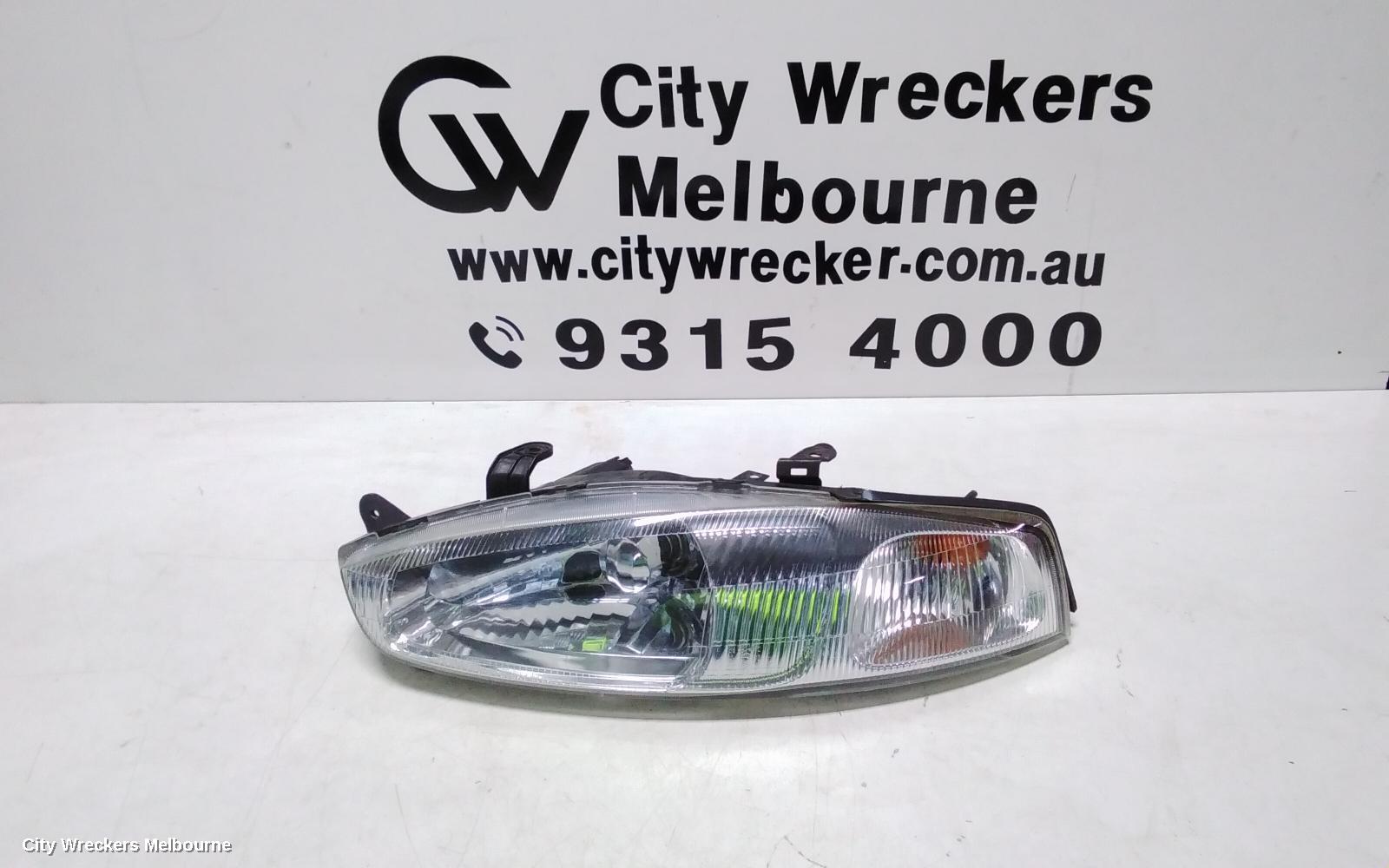 MITSUBISHI LANCER LEFT HEADLAMP, CE/CJ, LANCER (MIRAGE NZ), HATCH/COUPE, 1 PIECE W/ CORNER LAMP, PLASTIC TYPE, 07/1996 - 08/2003 - Image 1